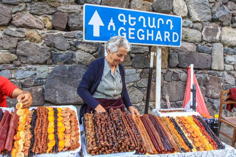 An old woman selling chir (Armenian sun-dried fruits) outside, next to Geghard Monastery