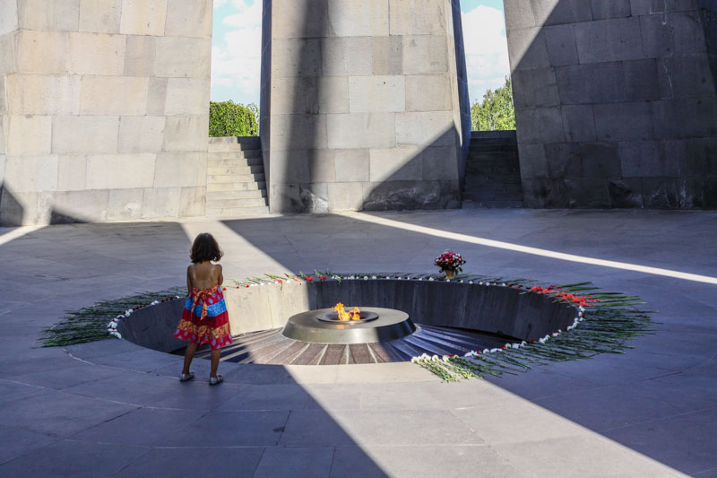 A girl looking at the eternal flame in the Armenian Genocide Memorial in Yerevan, Armenia