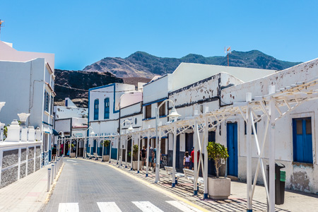 Calle con casas blancas y azules en Agaete, pueblo de pescadores de Gran Canaria