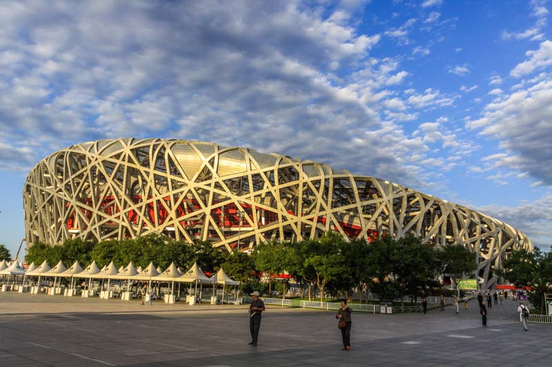 Beijing Olympic Stadium (Bird's Nest) during golden hour at sunset with dramatic clouds