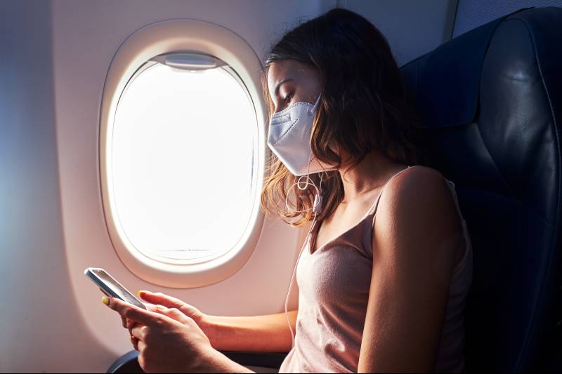 female model with kn95 mask in airplane