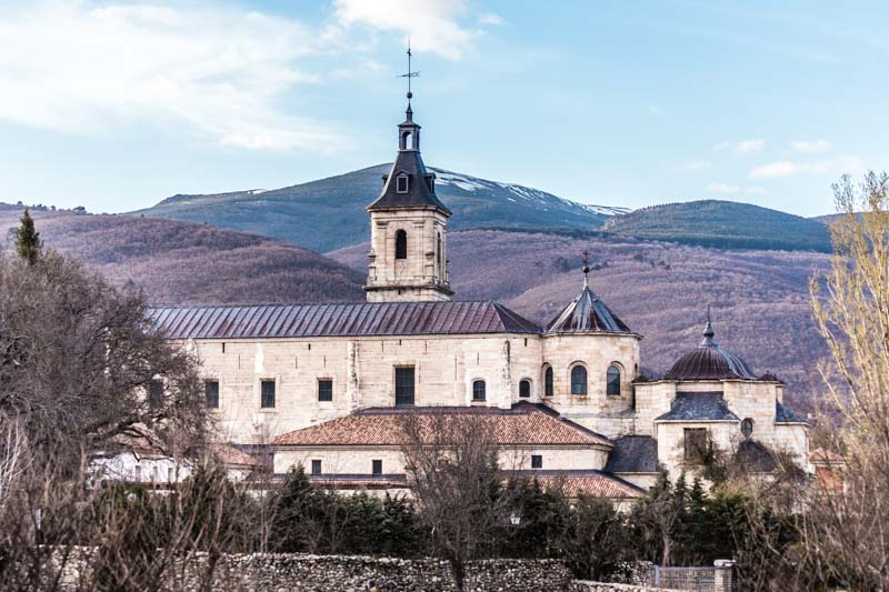 Fachada del Real Monasterio de Santa María de El Paular con la Sierra de Guadarrama al fondo en Rascafría, Madrid