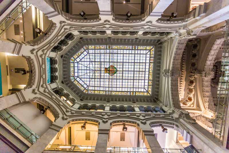 Ceiling with stained glass and columns in monumental post office city hall in Madrid, Spain