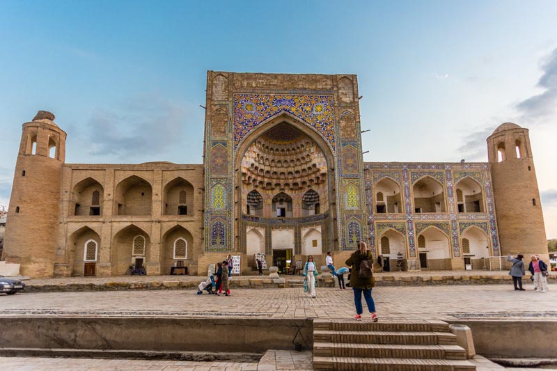 Bujará, Uzbekistán: Madrasa de Abdulaziz Jan al atardecer, con fachada con preciosos mocárabes