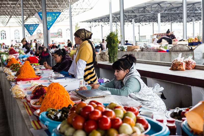 Mujeres vendiendo tomates, zanahorias y otras verduras encurtidas en el mercado central (bazar) de Samarcanda, Uzbekistán