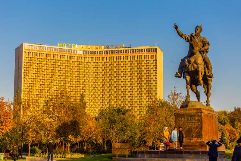 Plaza de Amir Timur en Tashkent, Uzbekistán, al atardecer. Arquitectura soviética del Hotel Uzbekistan y estatua de Amir Timur, héroe nacional.